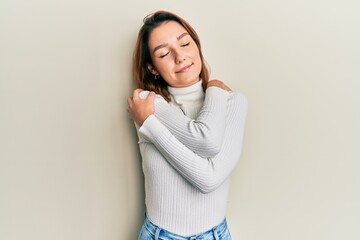 Young caucasian woman wearing casual clothes hugging oneself happy and positive, smiling confident. self love and self care