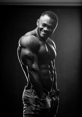 African American bodybuilder man, naked muscular torso, wearing jeans, isolated on black background