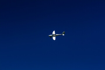 The plane flies in the blue sky