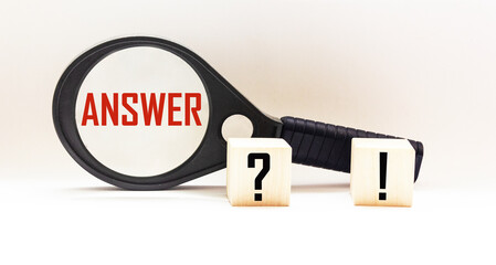 On a white background a magnifying glass with the word ANSWER and two cubes with a question mark and an exclamation mark