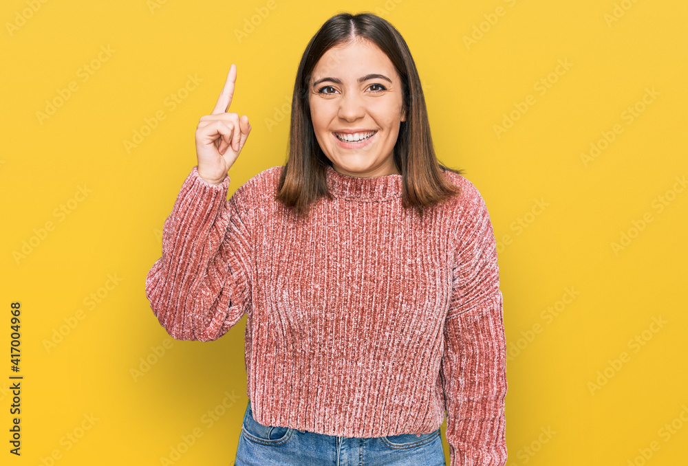 Sticker young beautiful woman wearing casual clothes pointing finger up with successful idea. exited and hap