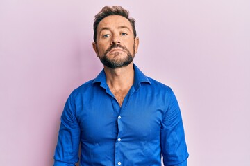 Middle age man wearing casual clothes relaxed with serious expression on face. simple and natural looking at the camera.