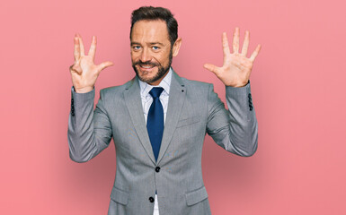 Middle age man wearing business clothes showing and pointing up with fingers number nine while smiling confident and happy.