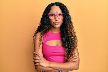 Young latin woman wearing casual clothes and glasses skeptic and nervous, frowning upset because of problem. negative person.