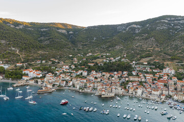 Fototapeta premium Aerial drone shot of Adriatic coastline in Komiza town on Vis Island in summer sunrise