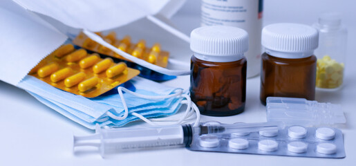 medical masks, glass bottles, pills, syringe and ampoules in the shopping bag