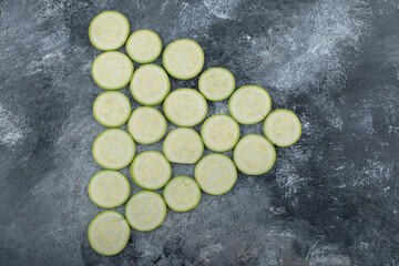 Fresh zucchini slices on a grey background on a triangle shape