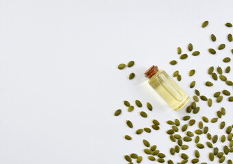 Pumpkin seeds and oil on a white background.