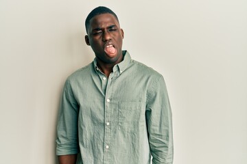 Young african american man wearing casual clothes winking looking at the camera with sexy expression, cheerful and happy face.