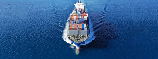Aerial drone ultra wide photo of colourful truck size container tanker ship cruising deep blue sea...