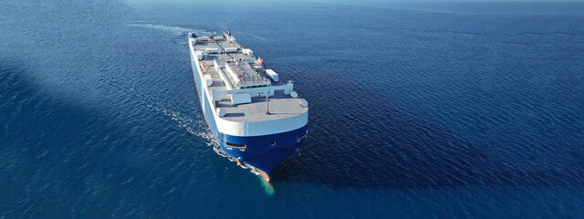 Aerial drone ultra wide photo of huge car carrier ship RO-RO (Roll on Roll off) cruising in...