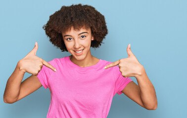 Young hispanic girl wearing casual clothes looking confident with smile on face, pointing oneself...
