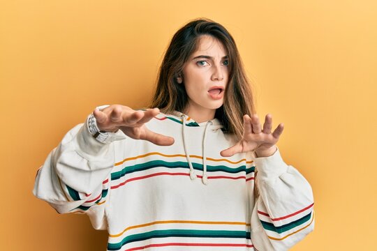 Young caucasian woman wearing casual clothes doing stop gesture with hands palms, angry and frustration expression