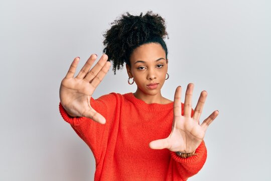 Young african american girl wearing casual clothes doing frame using hands palms and fingers, camera perspective
