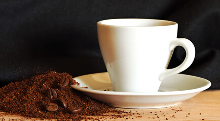 Ground coffee, coffee beans and a coffee cup. Selective focus.