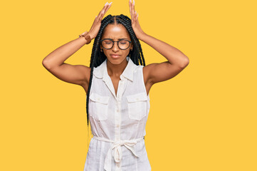 Beautiful hispanic woman wearing casual clothes and glasses suffering from headache desperate and stressed because pain and migraine. hands on head.