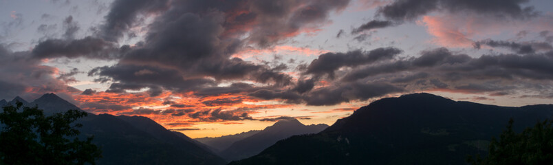 Rote leuchtende Wolken zur vor dem Sonneaufgang über dem Goms