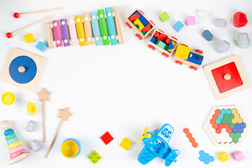 Colorful educational and musical toys for baby kids on white background. Top view, flat lay frame