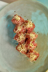 Top view of delicious red tuna sushi rolls set decorated with spouts served on a plate