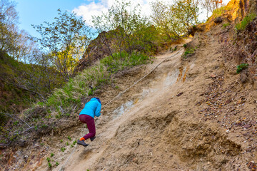 tourist tries to climb the mountain with a rope. Sakhalin Island Russia