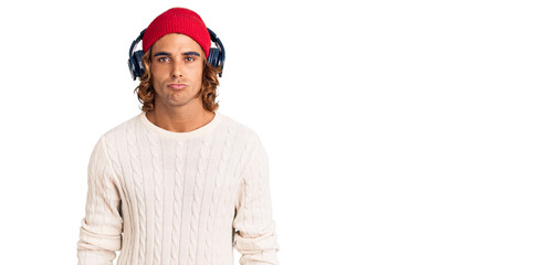 Young hispanic man listening to music using headphones depressed and worry for distress, crying angry and afraid. sad expression.