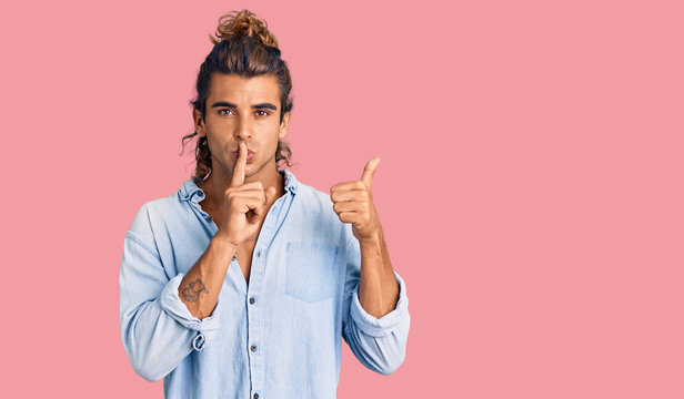 Young hispanic man wearing summer style asking to be quiet with finger on lips pointing with hand to the side. silence and secret concept.