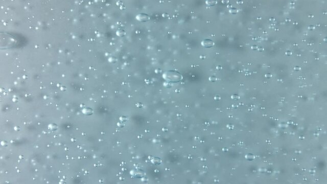 Blue serum texture, clear liquid gel background. Motion of the transparent beauty skincare product sample with bubbles. Top view. Macro Shot. High quality 4k footage