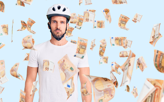 Young handsome man wearing bike helmet depressed and worry for distress, crying angry and afraid. sad expression.