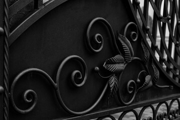 Forged metal elements of the gate in black and white tones of a private house