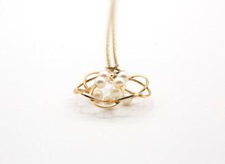Golden chain necklace with pearl pendant on white background. Jewel Design.