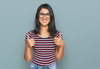 Beautiful asian young woman wearing casual clothes and glasses success sign doing positive gesture...