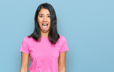 Fototapeta premium Beautiful asian young woman wearing casual pink t shirt sticking tongue out happy with funny expression. emotion concept.