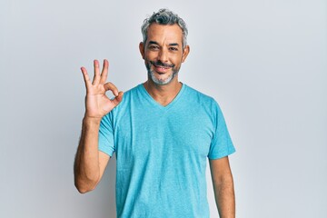 Middle age grey-haired man wearing casual clothes smiling positive doing ok sign with hand and fingers. successful expression.