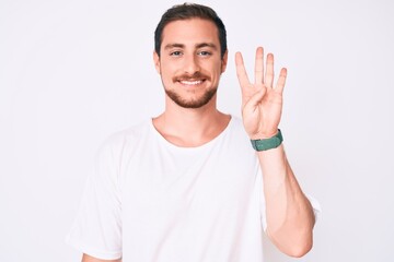 Fototapeta premium Young handsome man wearing casual white tshirt showing and pointing up with fingers number four while smiling confident and happy.