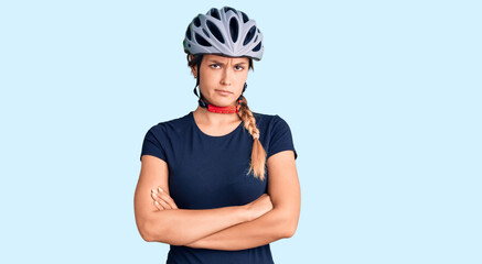 Beautiful caucasian woman wearing bike helmet skeptic and nervous, disapproving expression on face with crossed arms. negative person.