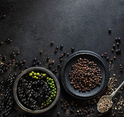 Background with black peppercorns in a dark colors with copy space