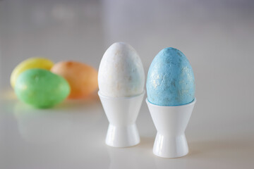 Easter concept. Two decorative eggs in white poached stands on a light background.