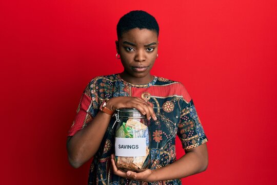 Young African American Woman Holding Savings Jar With South African Rands Money Skeptic And Nervous, Frowning Upset Because Of Problem. Negative Person.