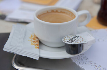 Cup of coffee in coffee with milk and waffle on a tray