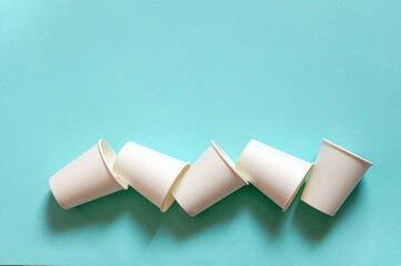 disposable white kraft paper cups stand on blue background