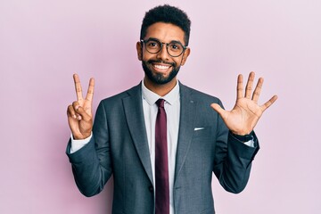 Handsome hispanic business man with beard wearing business suit and tie showing and pointing up with fingers number seven while smiling confident and happy.