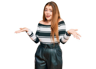 Young beautiful redhead woman wearing elegant clothes clueless and confused expression with arms...