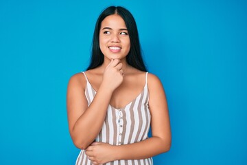 Obraz premium Young beautiful asian girl wearing casual clothes with hand on chin thinking about question, pensive expression. smiling with thoughtful face. doubt concept.