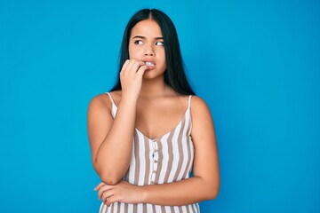 Young beautiful asian girl wearing casual clothes looking stressed and nervous with hands on mouth biting nails. anxiety problem.