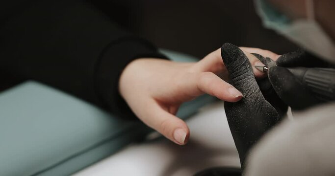 Closeup photo of making manicure using electric equipment for nails. Sterile and cleanness. Сeramic cutter.
