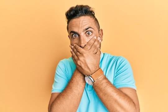 Handsome man with beard wearing casual clothes shocked covering mouth with hands for mistake. secret concept.