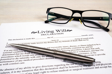 Living will declaration form with pen and glasses on top.