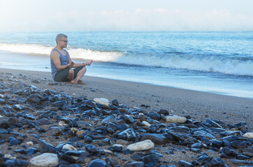 Man meditating on the beach