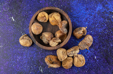 Bowl of dried figs on blue background