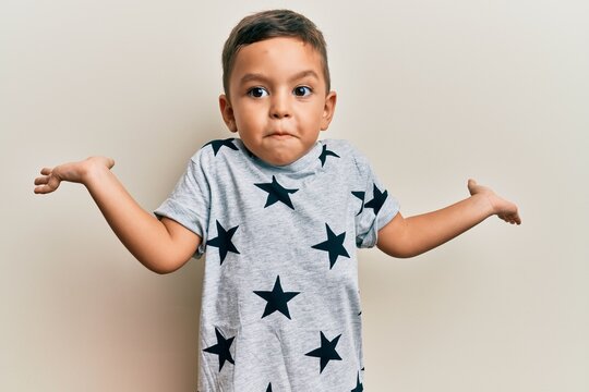 Adorable latin toddler wearing casual clothes clueless and confused with open arms, no idea and doubtful face.